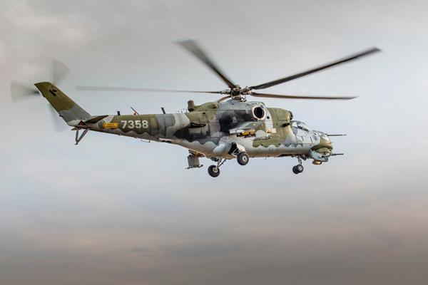 camo helicopter in flight through grey skies